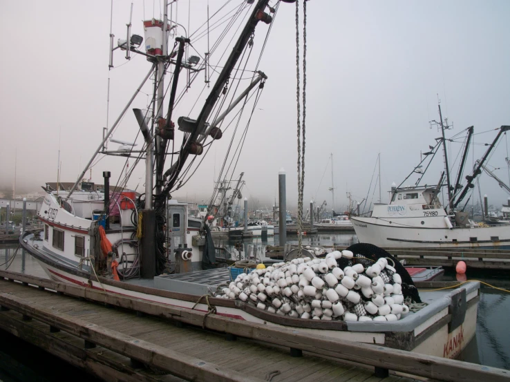 a dock area with ships docked and a pile of buoys