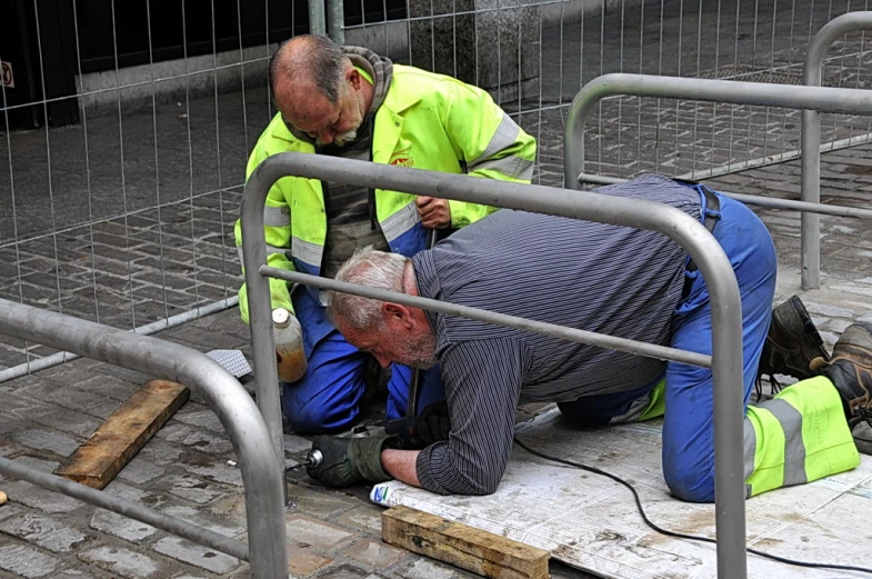 a man wearing a vest is giving another man some work