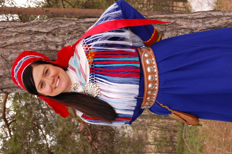 a  wearing a costume standing in front of a tree