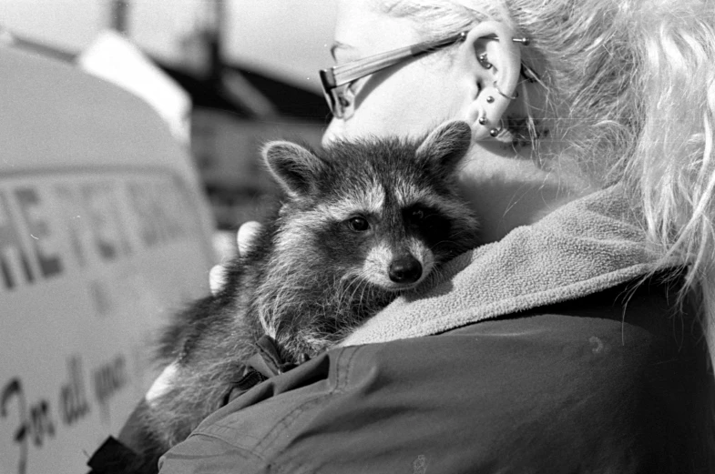 black and white pograph of a baby ra being held in a person's arms