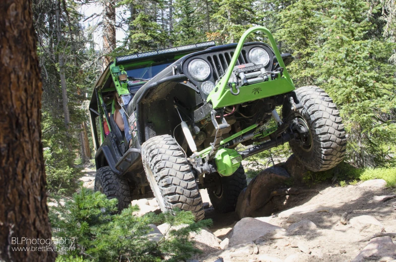 a jeep on the side of a trail in the woods