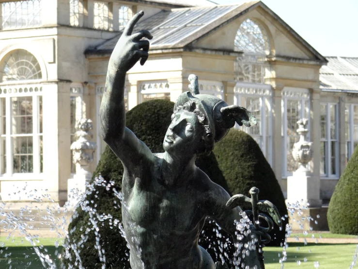 a statue of a boy with his hand up next to the fountain