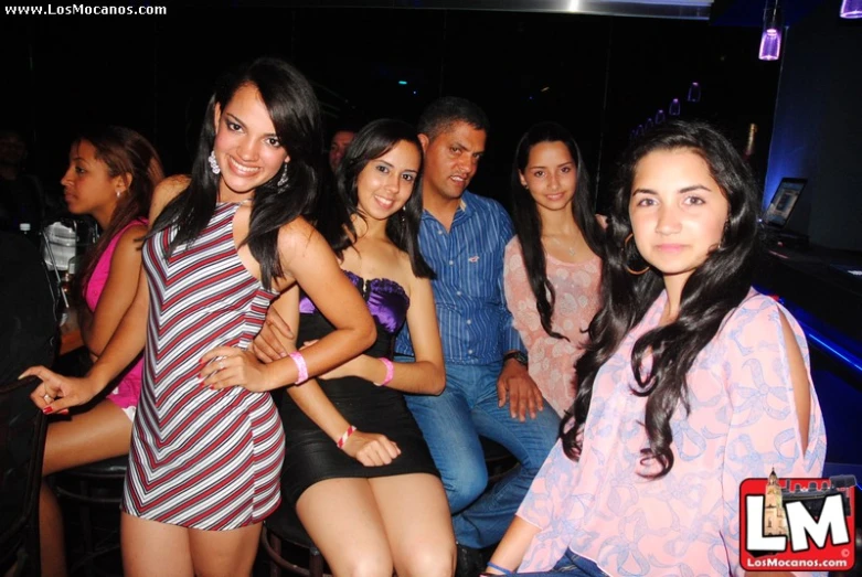 young adults in club attire posing for a picture