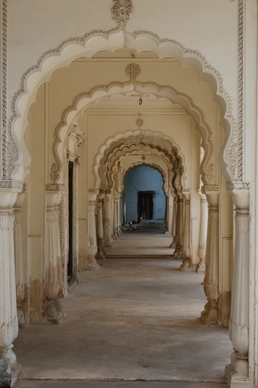 a room with many pillars and a walkway