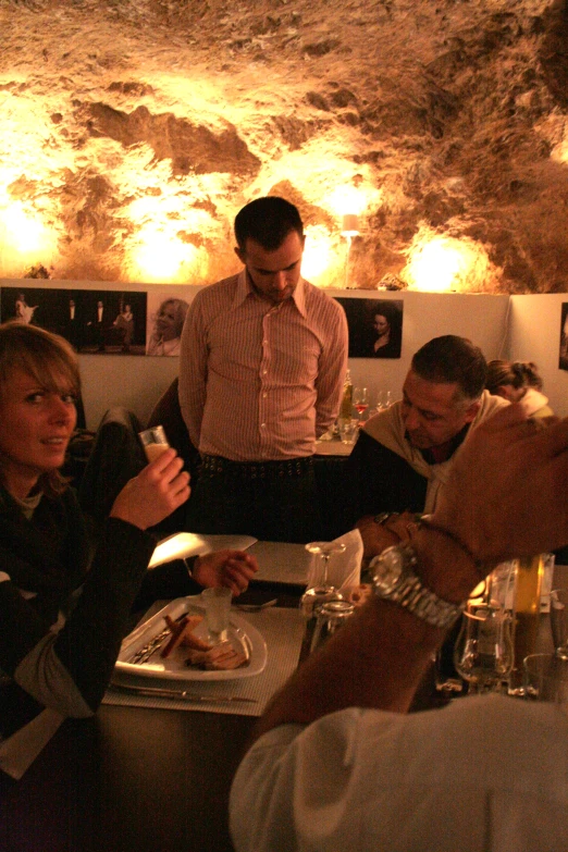 a group of people sitting at a table with food