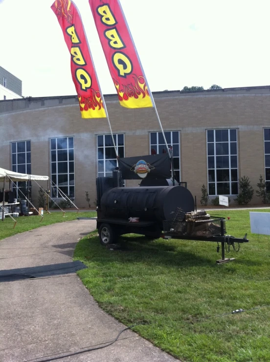 two large flags advertise bbq are blowing in the wind