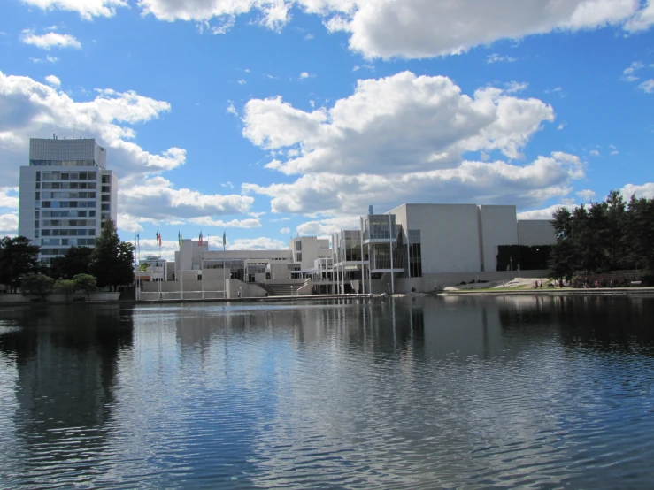 a pond near some buildings on a sunny day