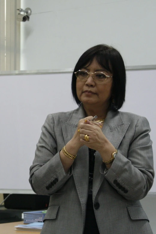 an older lady wearing glasses is sitting at a desk