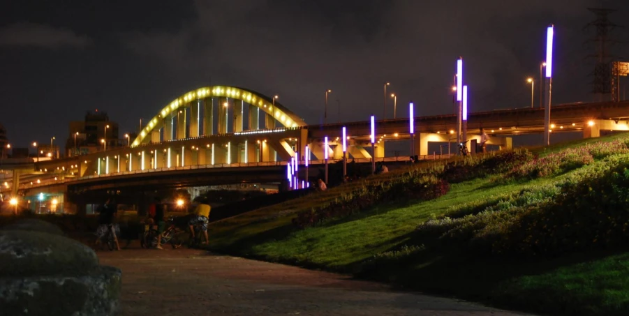 a large yellow bridge is at night time