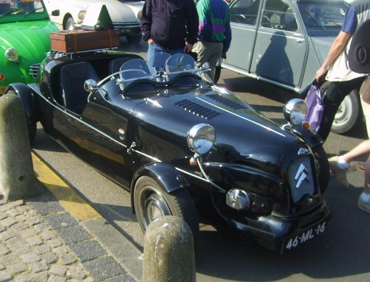 an old fashioned race car is being displayed on a street