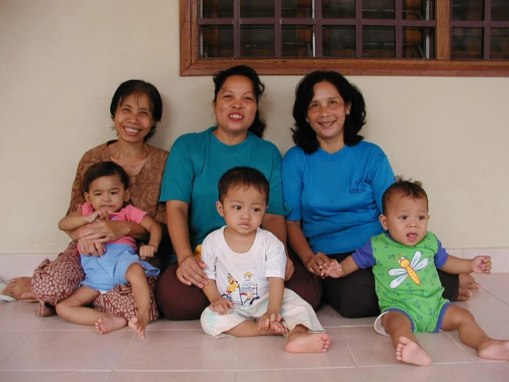 an asian family sitting on the floor and posing for a po