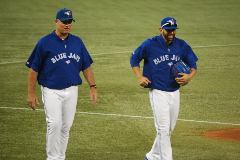 two baseball players walk in the grass during a game