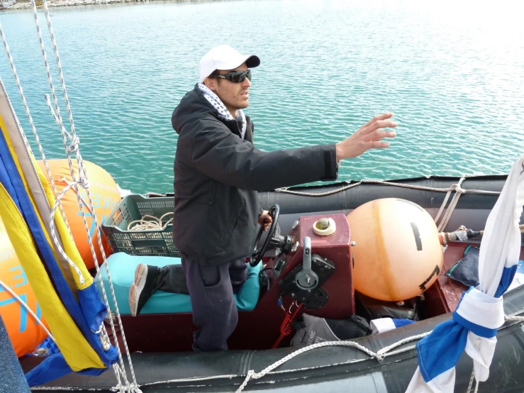 the man is standing near the luggage on a boat