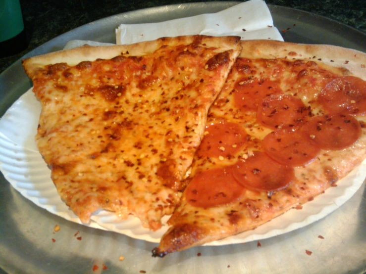 two slices of pizza on a paper plate
