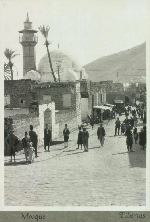 a group of men walking across a street past a stone structure