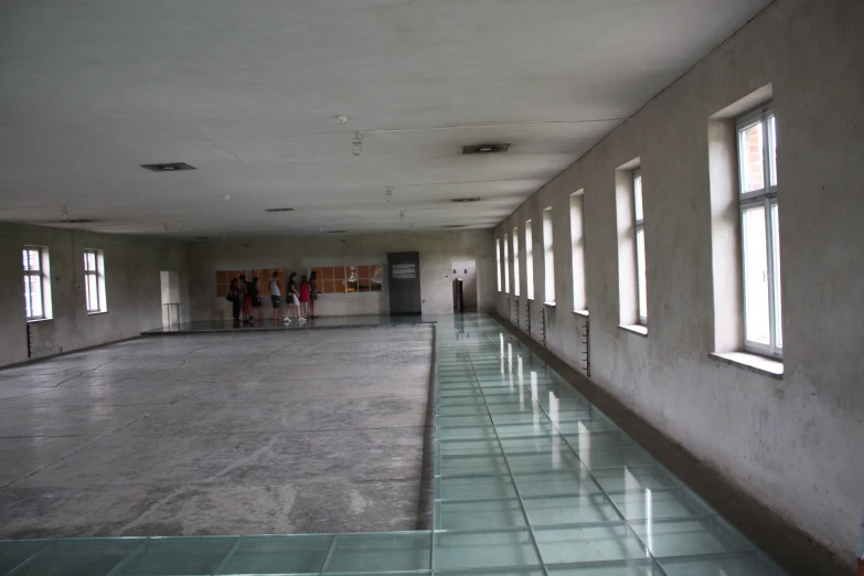 people are standing in a long empty building