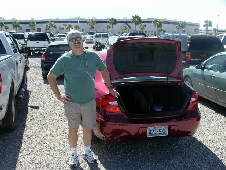 a man standing next to a trunk open in a parking lot