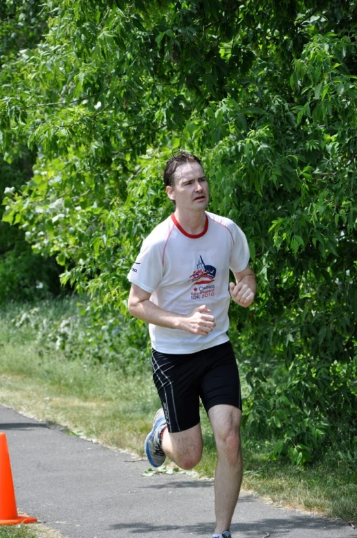 man running on street during daytime near bush