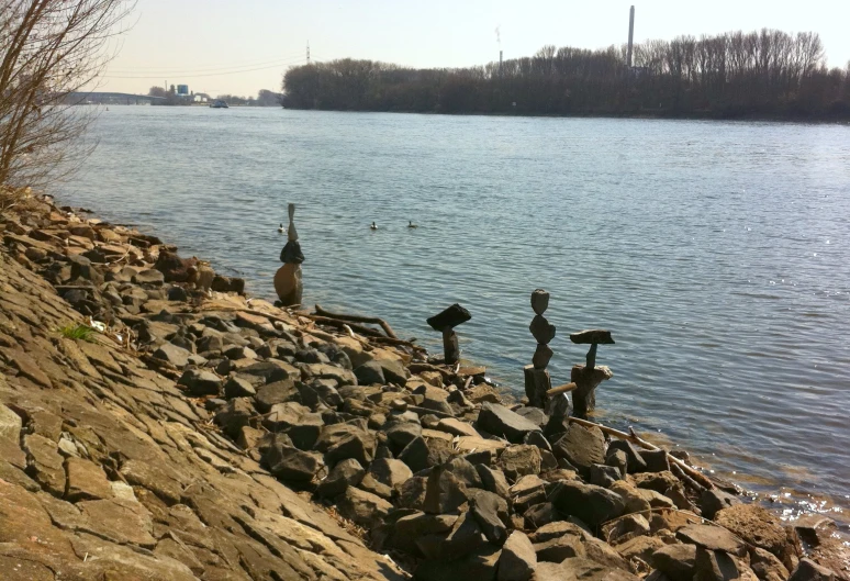 statues of birds are shown by the water's edge