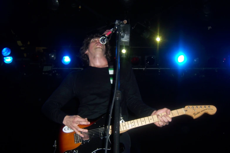 a person with glasses on his head playing a guitar