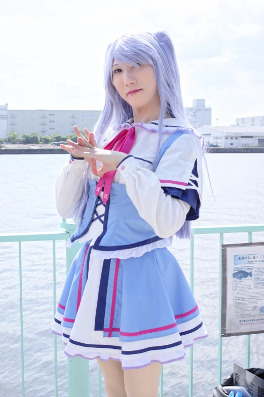 a person with silver hair is standing next to the water