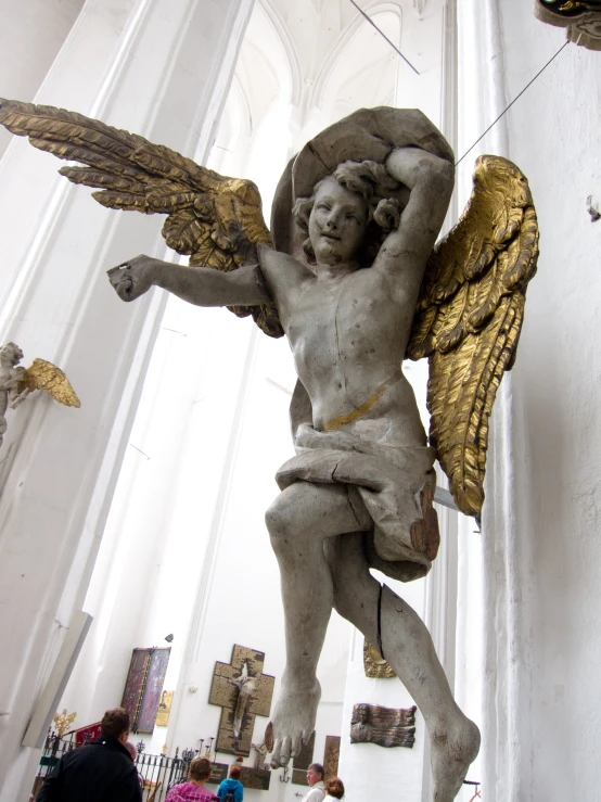 the angel statue is painted white and has gold wings