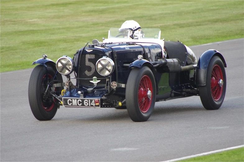 an antique car is speeding down the road