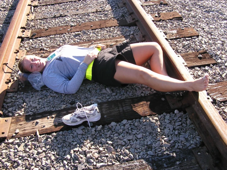 there is a woman laying on the train tracks