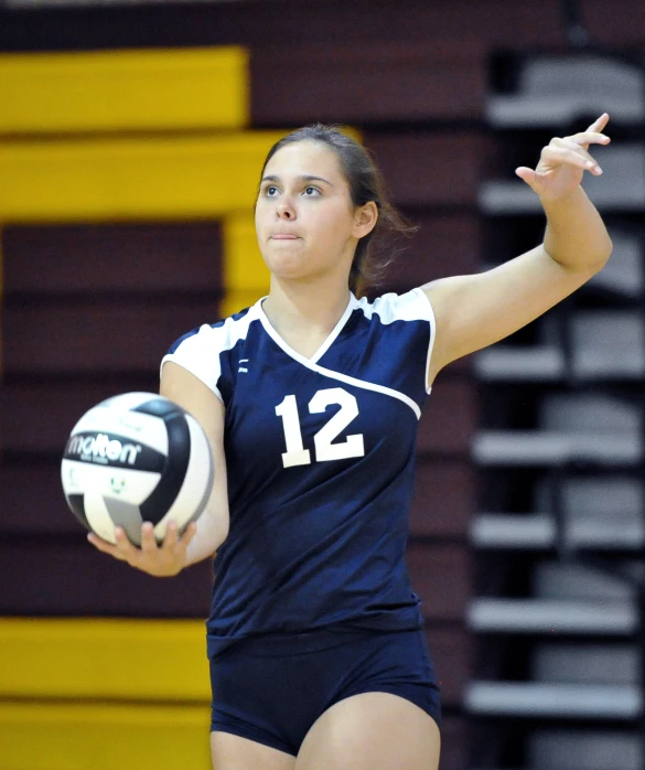 a woman holding a volleyball in one hand and a ball in the other