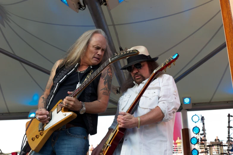 two man standing under an umbrella playing guitars