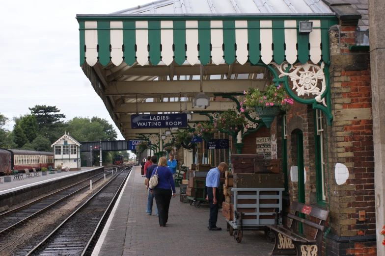 passengers are walking on the platform beside a train