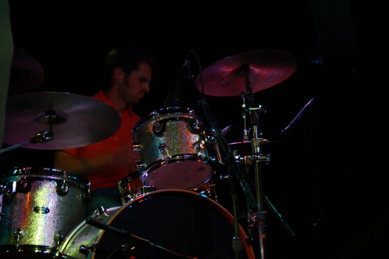drummer playing with colorful lights in the dark