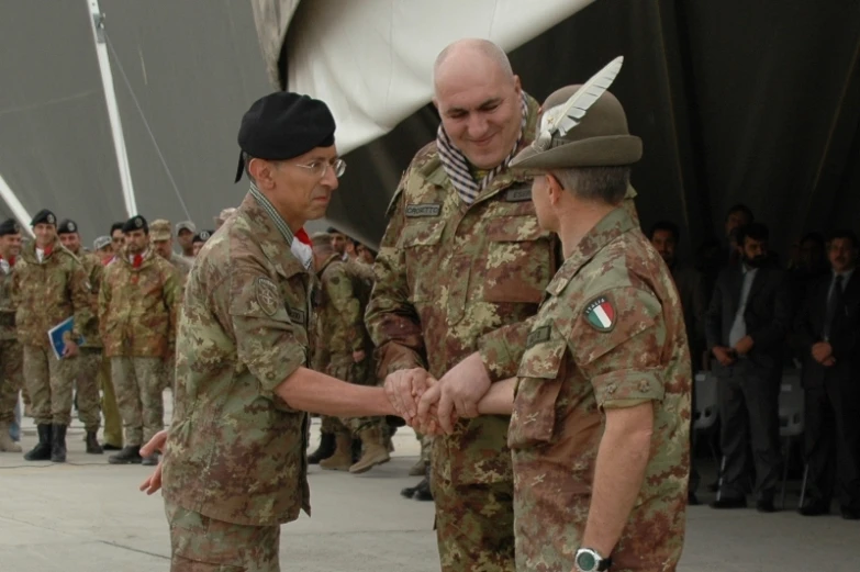 a soldier shaking another soldier hand during a ceremony