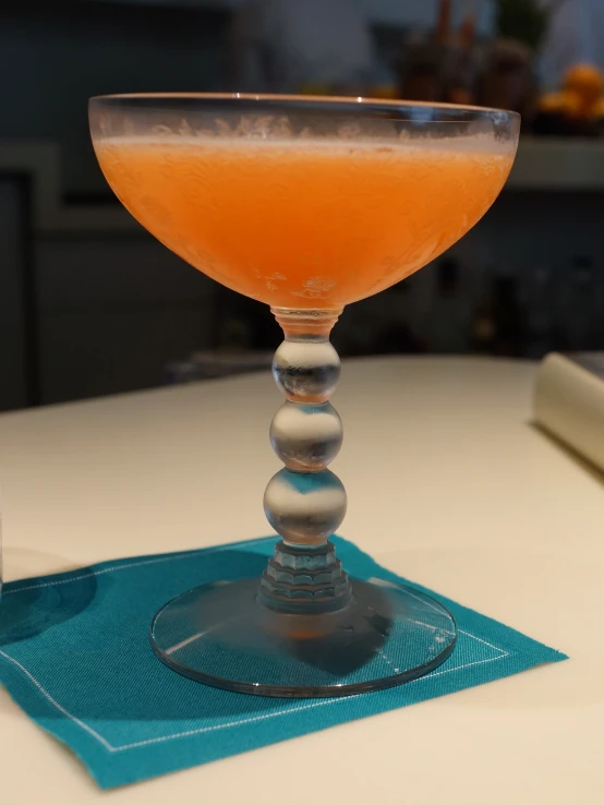 a glass full of orange drink sitting on top of a table