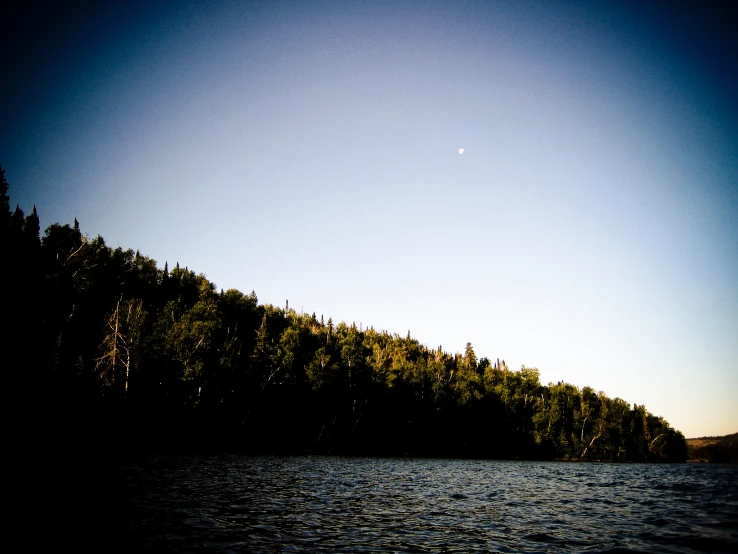 a mountain in the distance is surrounded by water