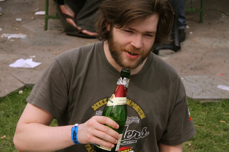 a man holding a bottle of beer and a glass