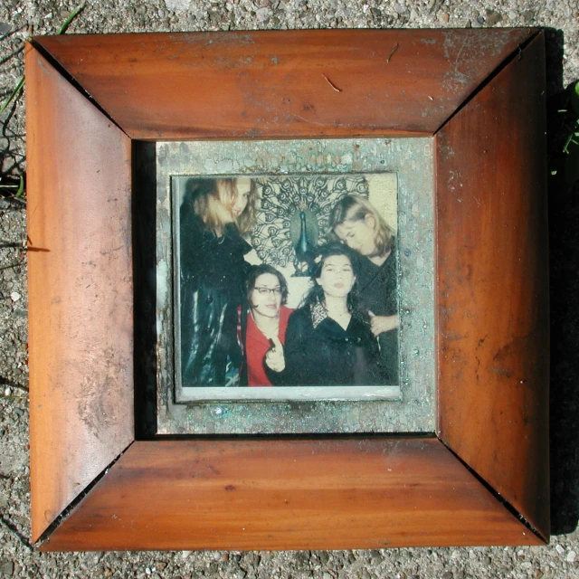 the frame on the concrete shows the picture of three women