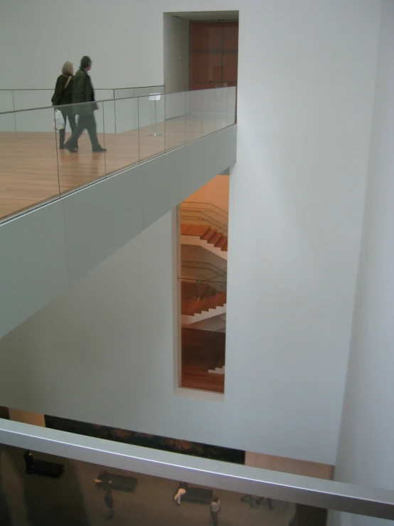 two people walking on a balcony in a building