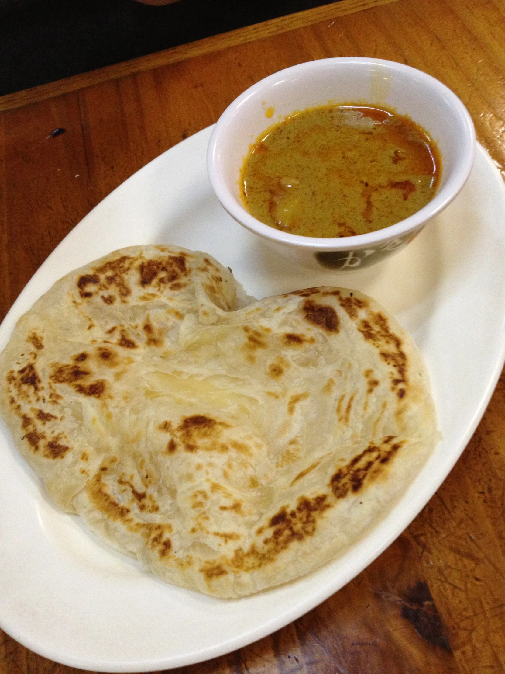 a plate with a tortilla on it and a cup of soup