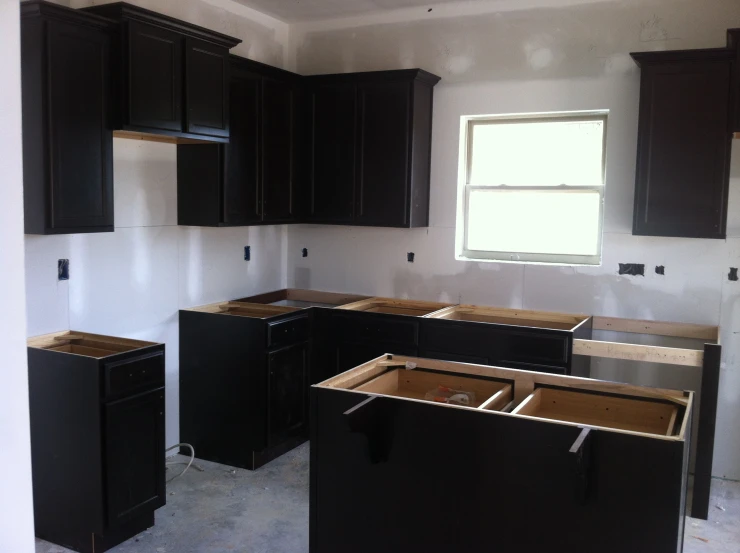 a room is under construction with all black cabinets