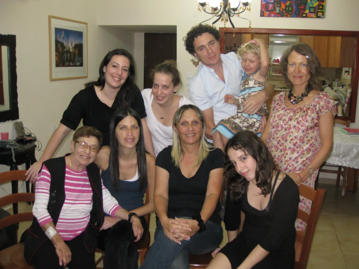 a family sitting down to pose for the camera