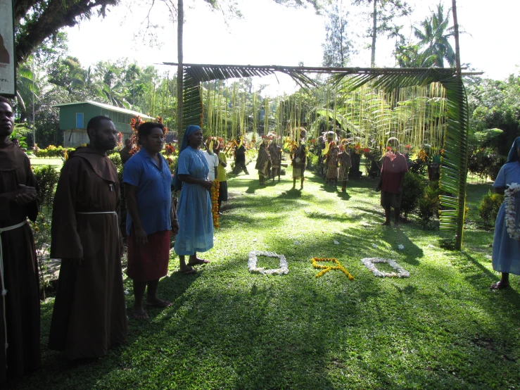 people gathered in a shaded area on green grass