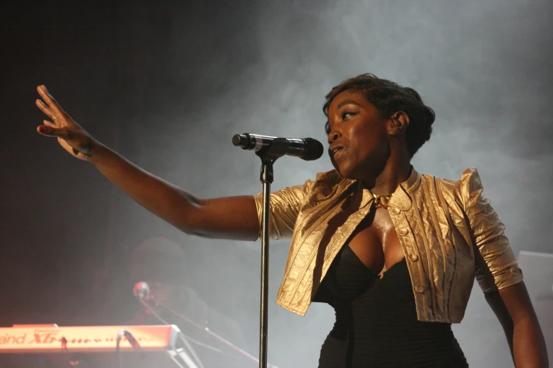 woman standing with hand out while speaking into microphone