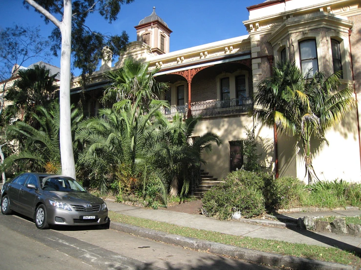 an elegantly decorated, brown home stands along a quiet street