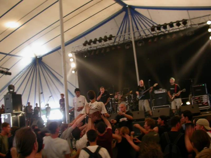 a band on stage with their hands in the air