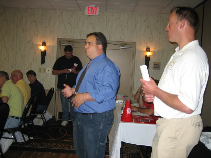 three men stand in front of a crowd and play a video game