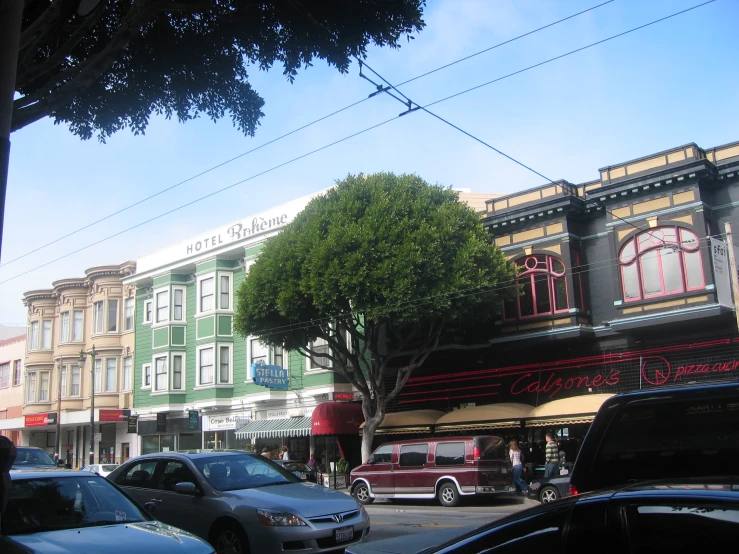 a group of parked cars on the street next to some buildings