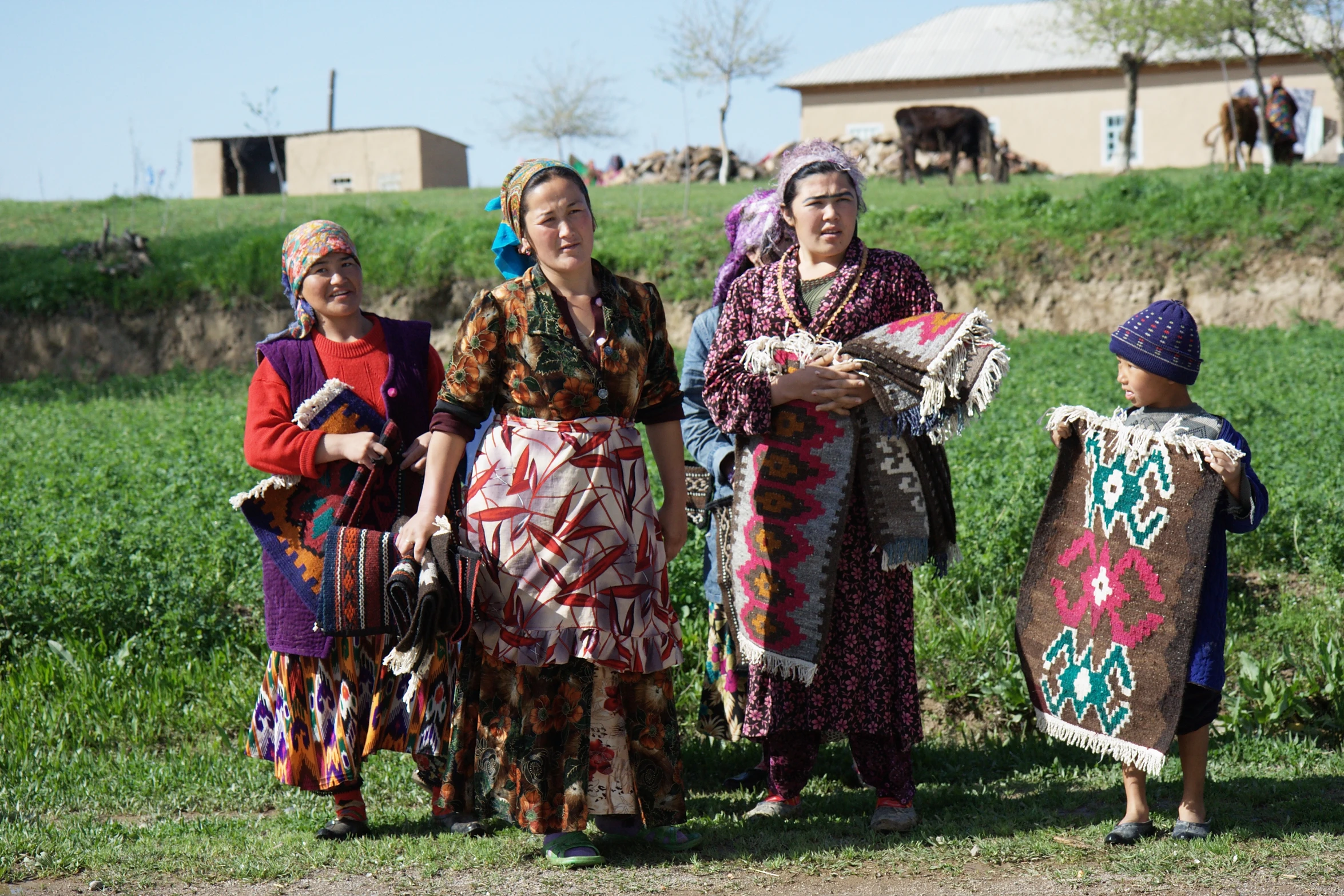 group of women wearing native clothing standing in the grass