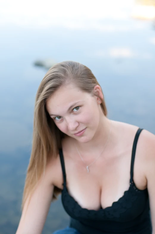 a women is posing next to a body of water