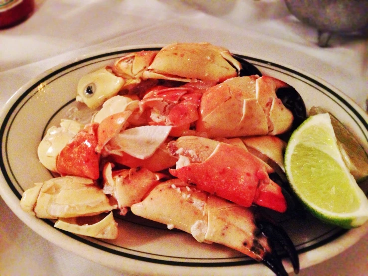 a plate of food with crab legs and lime